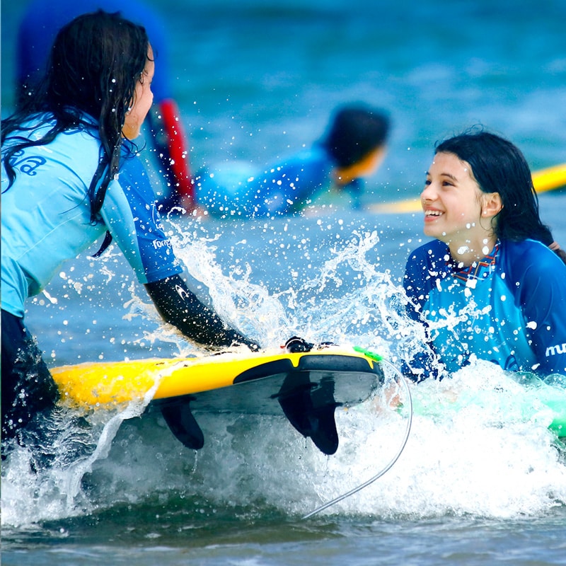alumnas disfrutando de clase de surf