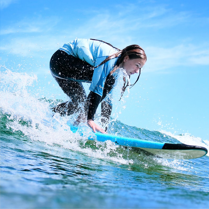 Alumna surfeando en clase de surf