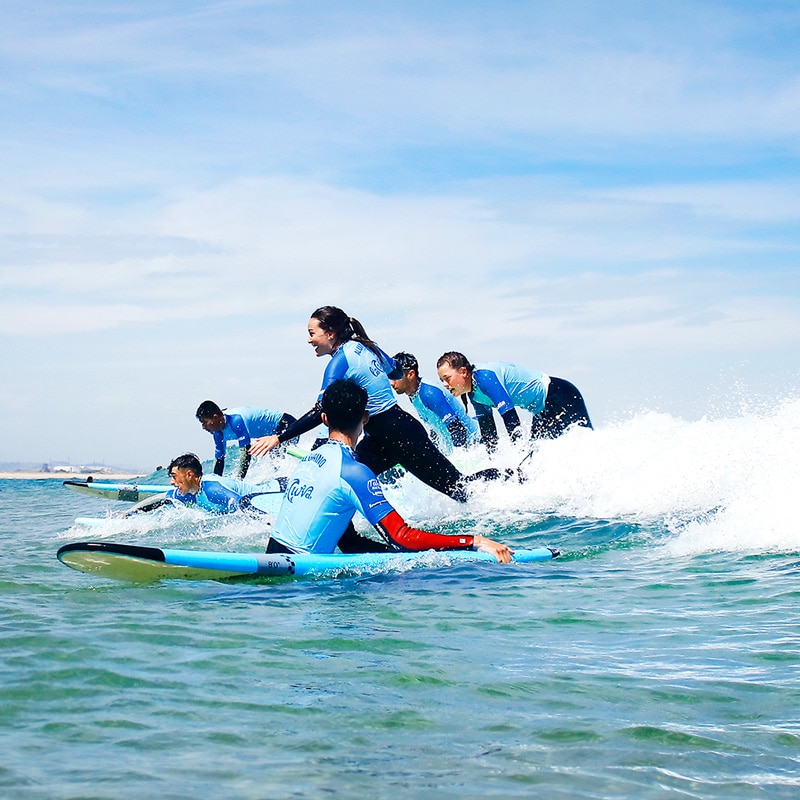 grupo de alumnos en surf camp surfenado